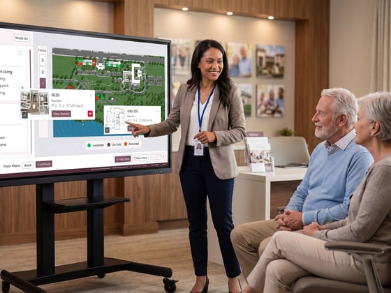 Senior living sales counselor using TouchTour on a touch screen to sell homes to a senior couple.